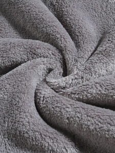 Macro shot of soft grey coral fleece fabric showing the thick plush texture of the hoodie