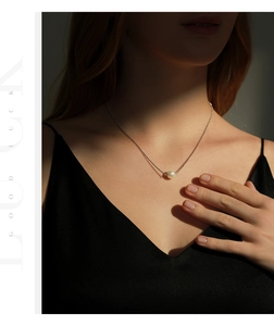 Detail of elegant s925 silver ball chain necklace with a single lustrous round pearl