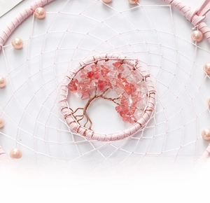 Detail of rose quartz tree of life dreamcatcher with pink feathers and suede