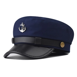 Close-up of navy blue military cap with silver anchor badge and leather brim detail