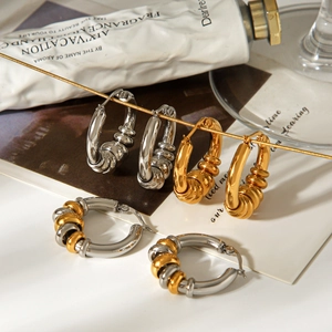 Detail of twisted hoop earrings in gold, silver, and two-tone finishes on elegant display