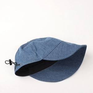 Detail view of denim bucket hat with adjustable black elastic drawstring and toggle