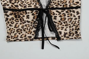 Close-up of leopard print top featuring intricate black lace trim and tie-up details