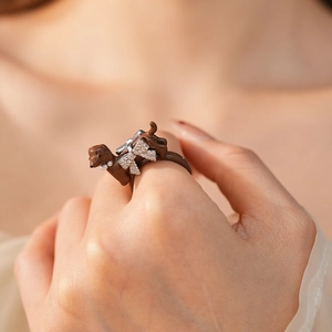 Detail of a brown dachshund ring with pearls and a sparkling diamond-set bow