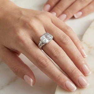 Detailed shot of emerald cut clear stone on silver twisted texture stainless steel ring