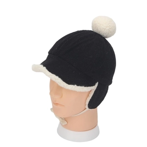 Détail d'un bonnet en tricot noir avec doublure polaire blanche et pompon pour enfants
