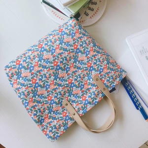 Borsa tote in cotone a fiori con manici in pelle in un ambiente di scrivania ordinata