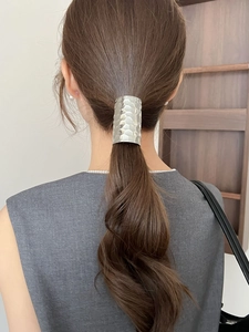 Detail of silver hammered metal hair clip used for a low ponytail decoration