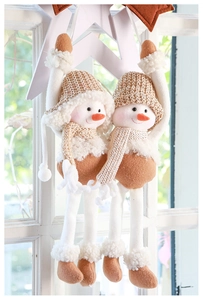 Detailed view of long-legged plush snowmen with knit hats and scarves on a window