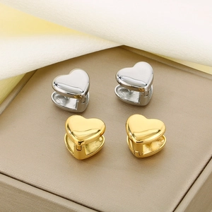 Polished heart hoop earrings in gold and silver finish on silk fabric detail