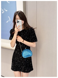 Blue shell-shaped crossbody bag with gold chain strap shown in mirror selfie style