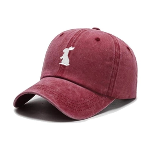 Close-up of a burgundy washed cotton baseball cap with white rabbit embroidery details