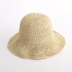 Close-up of tightly woven straw fiber texture on a beige summer sun hat for women