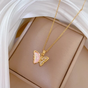 Detailed close-up of a golden butterfly necklace with pink inlay and sparkling crystals