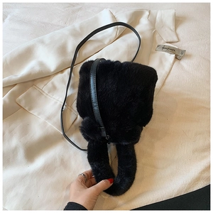 Détail du sac seau noir en fausse fourrure avec poignée épaisse et bandoulière