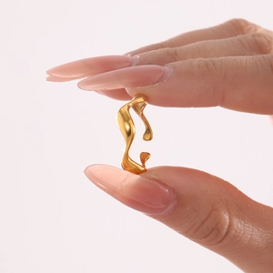 Minimalist gold fluid wave ring with polished finish shown on a woman finger