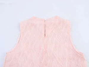 Dettaglio dell'abito rosa senza maniche con frange piumate e chiusura a bottone sul retro