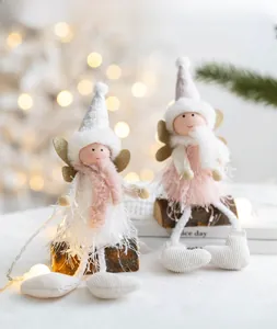 Detail of Christmas angel plush dolls featuring knit hats, feather skirts and gold wings