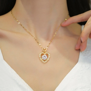 Luxurious gold heart pendant necklace with shimmering crystals on a woman's collarbone