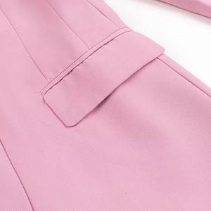 Dettaglio della tasca piatta del blazer rosa che mostra il tessuto e le cuciture fini
