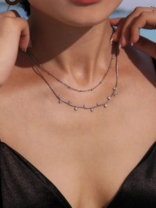 Détail du collier double chaîne serpent argentée avec des pierres de zircone brillantes