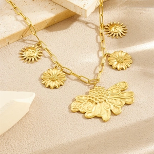 Gold vintage sunflower necklace with sun pendants on a textured stone surface