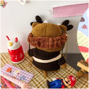 Rear view of cute plush Shiba Inu shoulder bag with golden chain strap on a desk