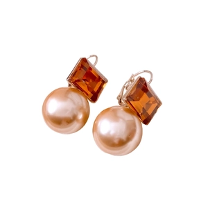 Boucles d'oreilles vintage avec cristal ambré et perle champagne sur fond blanc pur