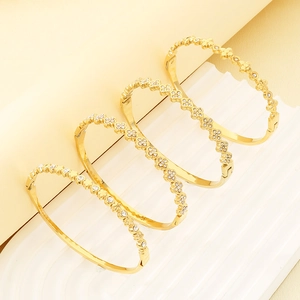 Set of four gold-plated clover open bangles with clear cubic zirconia pavé detailing