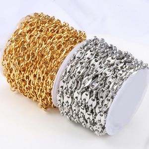 Detail of gold oval link and silver coffee bean chains on spools for DIY jewelry making