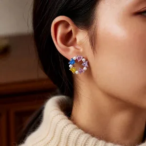 Elegant silver circle earrings with colorful heart crystals and pearls worn by a model