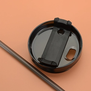 Detail of black plastic lid with sliding cover and matching straw for insulated tumbler