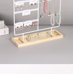 Detail of white metal jewelry stand with solid wood base and earring hanging holes