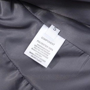 Détail de l'étiquette d'entretien montrant la taille S et le tissu 100% polyester