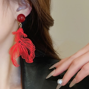Macro view of a red goldfish drop earring with detailed metal hollow-out craft and bead