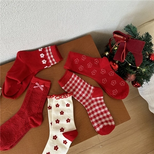 Flat lay of red and white Christmas socks with bow details and holiday patterns