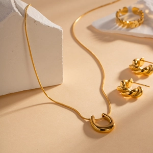 Detailed set of 18K gold plated horseshoe pendant necklace with twisted earrings and ring