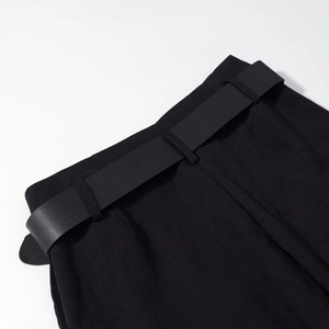 Close-up of black casual shorts waistband featuring a matching minimalist belt and fine fabric