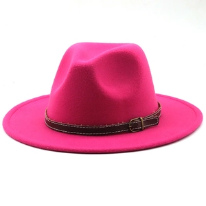 Detail of hot pink fedora hat with a brown leather decorative band and metal buckle
