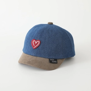 Dettaglio del ricamo a cuore su cappello da baseball in denim patchwork con visiera marrone