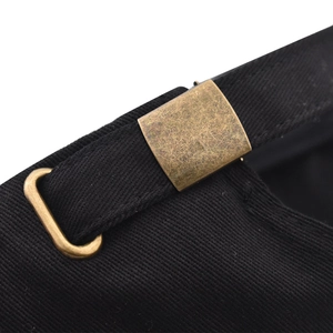 Detail of black cotton baseball cap with adjustable antique bronze metal buckle closure