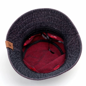 Detail view of denim bucket hat with red lining, leather patch and adjustable inner strap