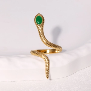 Gold snake ring with green stone accent and detailed scales on textured background