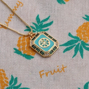 Vue rapprochée du collier doré rectangulaire avec émail turquoise et étoile boussole