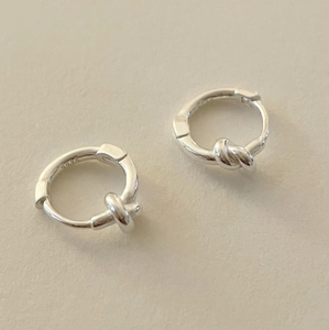Detail shot of the S925 silver stamp on a minimalist knotted sterling silver earring hoop