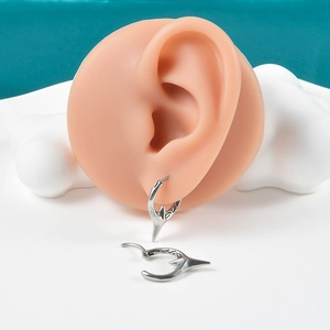 Macro view of vintage silver punk hoop earrings with spike pendants on a model ear