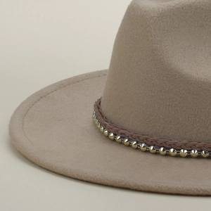 Detail of camel wool fedora hat with brown braided band and gold metallic studs