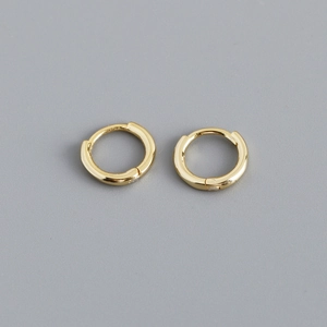 Detail view of small polished gold hoop earrings with a secure snap closure design