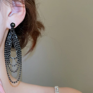 Gros plan de boucles d'oreilles pampilles noires à cristaux sur le profil d'un mannequin