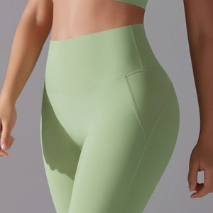 Detail of high-waist light green yoga leggings with reinforced seams and matte finish